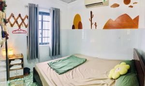 a bedroom with a bed with a teddy bear on it at Homestay Bảo Nhi in Chợ Phước Hải