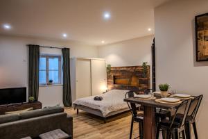 a living room with a bed and a table and a couch at Le Ptit Chauffour - Hyper Centre Ville - Transports en Commun - Commerces à Proximité in Colmar