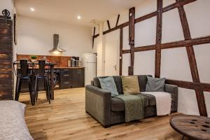 a living room with a couch and a kitchen at Le Ptit Chauffour - Hyper Centre Ville - Transports en Commun - Commerces à Proximité in Colmar