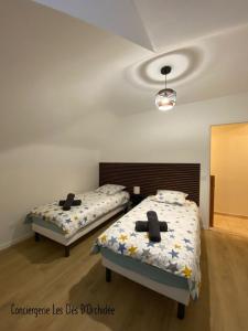 two beds in a room with two bedsskirts at L'Instant Loire in Saumur