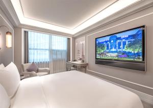 a hotel room with a large bed and a flat screen tv at Mercure Xi'an High-tech Zone Center in Xi'an