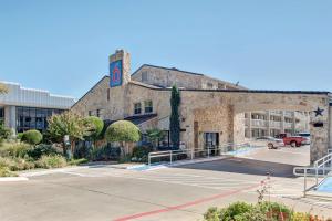 un gran edificio con un estacionamiento delante de él en Motel 6-Dallas, TX - Forest Lane, en Dallas