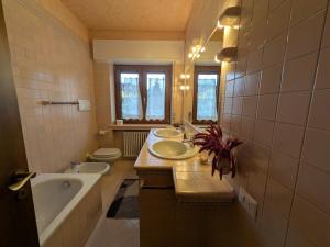 a bathroom with three sinks and a tub and a toilet at Casa Stocke - Relax e natura in Contrà Zocchi in Asiago