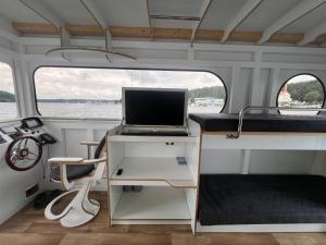 ein Laptop, der auf einem Schreibtisch in einem Wohnmobil steht in der Unterkunft Hausboot Rollyboot Evolution 2- feste Unterkunft am Steg in Joachimsthal + 17 Fotos