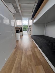 ein Zimmer mit einem Bett und einem Holzboden in der Unterkunft Hausboot Rollyboot Evolution 2- feste Unterkunft am Steg in Joachimsthal