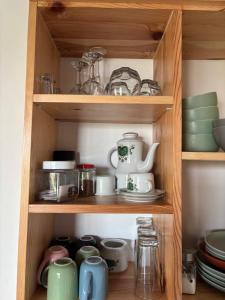 a cupboard filled with dishes and other kitchen items at Domek nad Bugiem z sauną in Bubel-Łukowisko