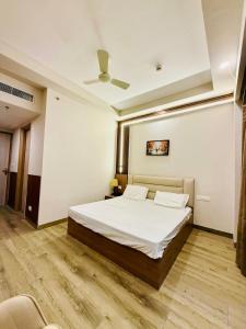 a bedroom with a white bed and a ceiling at SR Luxury steys in Greater Noida