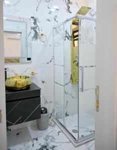 une salle de bain avec une douche en verre et un lavabo dans l'établissement For daily, weekly monthly and yearly stays, à Amman