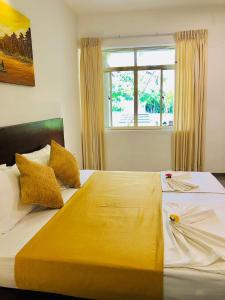 um quarto com uma cama grande e uma janela em Paradise Garden Beruwala em Beruwala