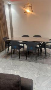 een houten tafel en stoelen in een kamer met een tafel bij Entire home in Haatso in Ashonman