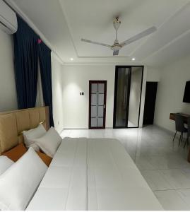 een slaapkamer met een groot bed en een plafondventilator bij Entire home in Haatso in Ashonman