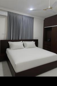 een slaapkamer met een groot bed met witte lakens bij Entire home in Haatso in Ashonman