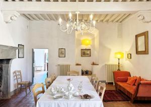 a dining room with a table and a chandelier at Chiantivillas Poggio a Vento in Badia A Passignano