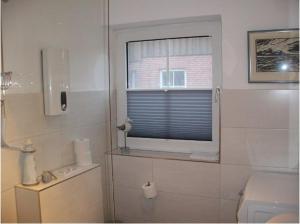 a bathroom with a toilet and a window at Design Wohnung in Petersdorf auf Fehmarn