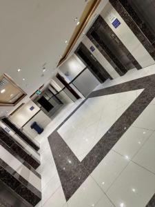 un hall d'entrée avec un sol carrelé avec une hache dessus dans l'établissement فندق الزائر الأخيار الفندقية, à La Mecque