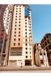 un grand bâtiment dans une rue de la ville avec des bâtiments dans l'établissement فندق الزائر الأخيار الفندقية, à La Mecque
