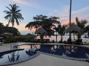 象岛安布尔沙滩度假村的棕榈树和日落度假村的游泳池