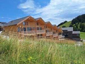 a wooden house with a fence in a field at StrohGlück Rigi - traumhafte nachhaltige Ferienwohnungen mit toller Aussicht in Rigi Kaltbad