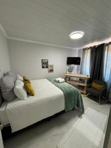 ein Schlafzimmer mit einem Bett und einer Couch und einem Fernseher in der Unterkunft Blue Bay Villa in Saldanha