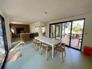 eine Küche und ein Esszimmer mit Tisch und Stühlen in der Unterkunft Villa Domus Sciurorum – Pyla-sur-Mer (Domaine Forestier) in Pyla-sur-Mer