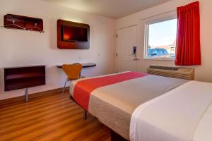 ein Hotelzimmer mit 2 Betten und einem TV in der Unterkunft Motel 6-Riverside, CA - South in Riverside