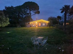 a house with two chairs and a table in the yard at LBCA maison campagnarde in Casteljaloux