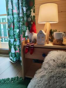 a toy elf is sitting on a table next to a lamp at Leśna Przystań - Domki całoroczne in Grywałd