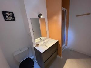 a bathroom with a sink and a toilet and a mirror at Port de Rochefort in Rochefort