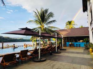 ルアンパバーンにあるMekong Theme Hostel,Affiliated by Huayeのリゾート内のプールの椅子に座っている人々とプールのプールを利用できます。