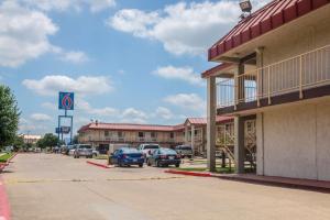 a parking lot with cars parked in front of a hotel at Motel 6-Mesquite, TX - Rodeo - Convention Ctr in Mesquite