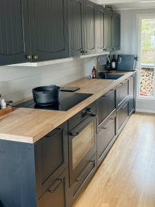a kitchen with gray cabinets and a wooden counter top at Fantastisk Hytte Med Udsigt Over Ytre Oslofjord in Gressvik +27 photos