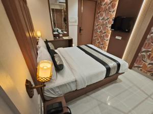 een hotelkamer met een bed en een televisie bij Hotel Melody Boutique Thane in Thane