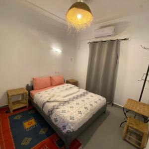a bedroom with a bed and a chandelier at Auberge Etoile Filante d Or Ait Ben Haddou in Aït Ben Haddou