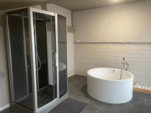 a bathroom with a large tub and a shower at Appartement dans un cadre bucolique in Charly-sur-Marne