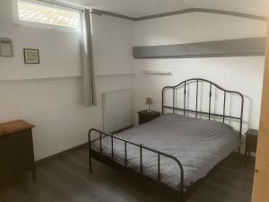 a bedroom with a metal bed and a window at Appartement dans un cadre bucolique in Charly-sur-Marne