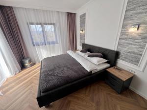 a bedroom with a black bed with a wooden floor at Casa Cențiu II in Bran