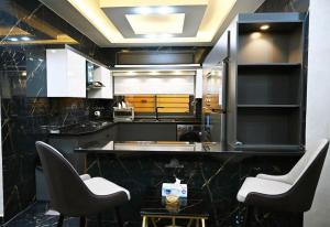 a kitchen with a counter with two chairs and a table at Sky Villa in Amman