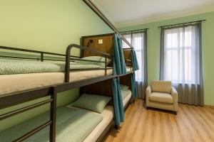 a bunk bed room with two bunk beds and a chair at Best Spot Hostel in Prague