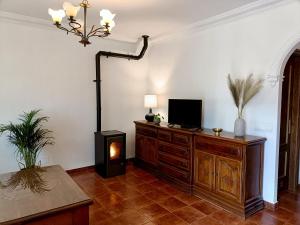 een woonkamer met een houten dressoir en een televisie. bij La Casa Del Platero in Ronda
