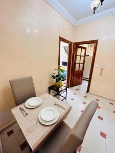 a dining room with a table and chairs and a door at Jolie appartement calme avec cheminée & bois in Ifrane