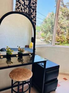 a dressing table with a mirror and a stool at Jolie appartement calme avec cheminée & bois in Ifrane