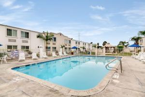 a swimming pool with lounge chairs and a building at Motel 6-Carson, CA in Carson
