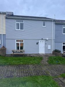 ein Haus mit einem Picknicktisch davor in der Unterkunft Cornwall Lodge sleeps 8 full Holiday Park Access in Saint Columb Road Station