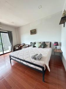 ein Schlafzimmer mit einem großen Bett in einem Zimmer in der Unterkunft littlehousekhaoyai ลิตเติ้ลเฮาส์เขาใหญ่ in Ban Bung Toei