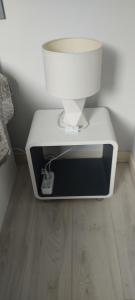 une lampe blanche posée sur une boîte dans l'établissement Agréable T2 au centre de Luchon, à Luchon