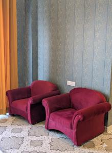 a red couch and a chair in a room at Qila Hotel in Pipalsāna +113 photos