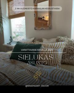 Schlafzimmer mit einem Bett mit einem Kissen und einem Spiegel in der Unterkunft Sielukas asunto funkistalossa in Karkkila