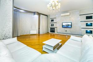 ein Wohnzimmer mit zwei weißen Sofas und einem Tisch in der Unterkunft Apartment On VIP Nizami Street in Baku