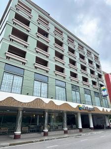 um grande edifício na lateral de uma rua em Hatyai Merridian Hotel em Hat Yai