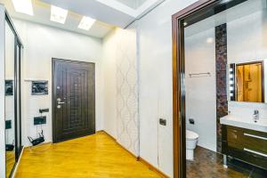 ein Badezimmer mit einer Tür und einer Toilette und einem Waschbecken in der Unterkunft Apartment On VIP Nizami Street in Baku + 64 Fotos